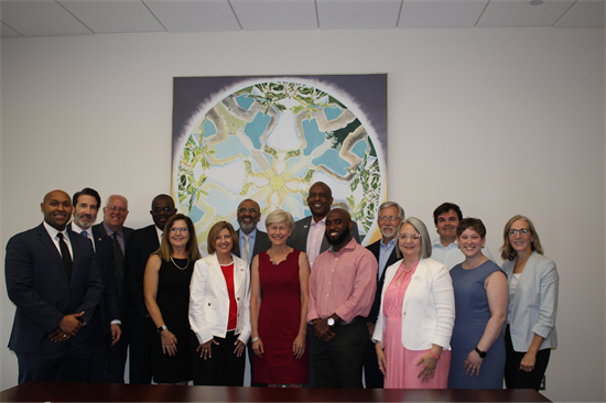 Rep Ross standing for a group photo with roundtable participants