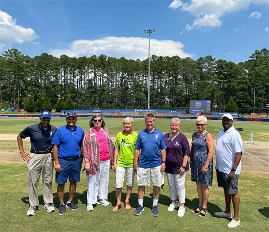 Rep Ross standing in the middle of a group photo on field